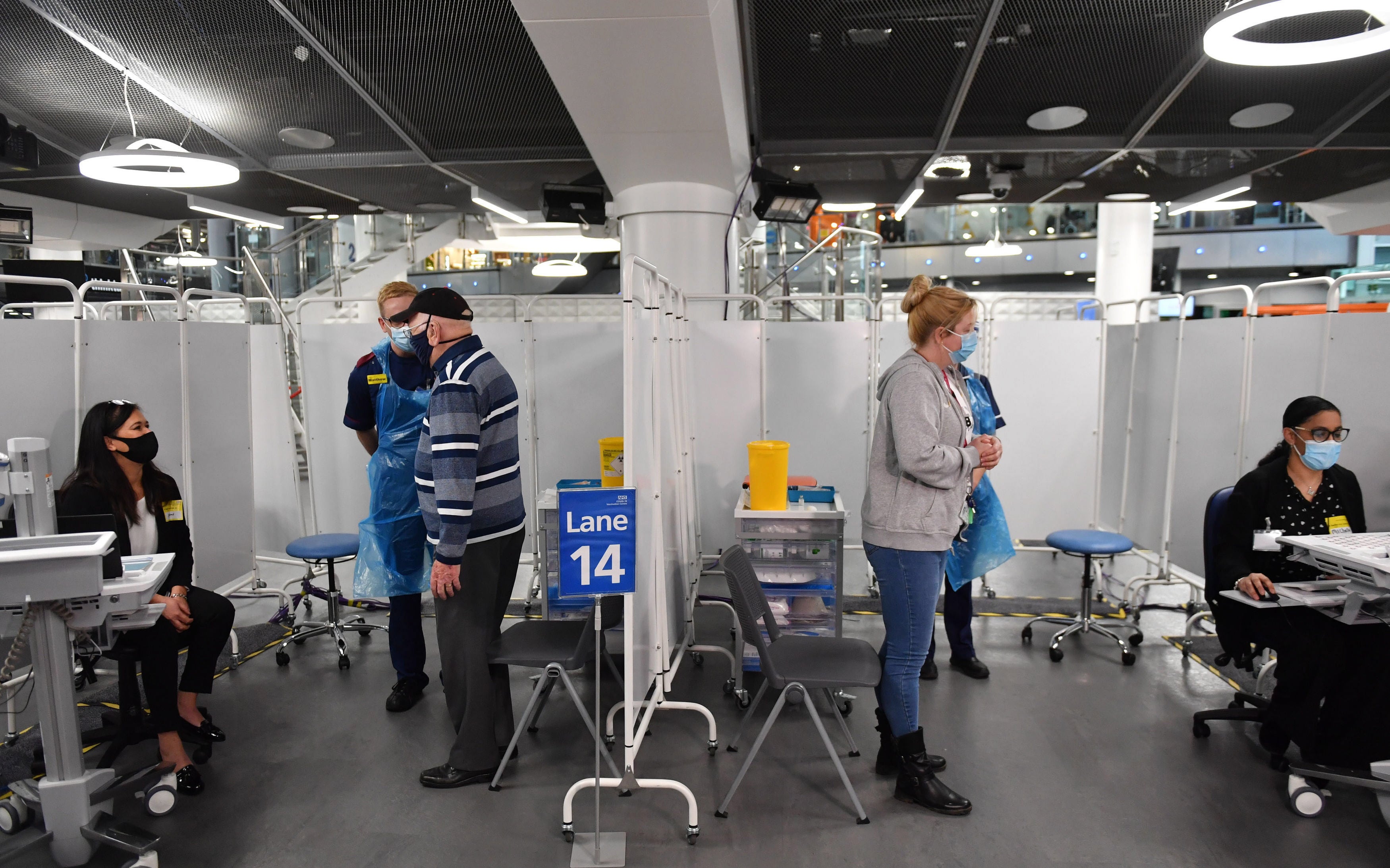 Members of staff talk to patients before administering an injection of a Covid-19 vaccine &nbsp;at the NHS vaccine centre that has been set up at the Millennium Point centre in Birmingham