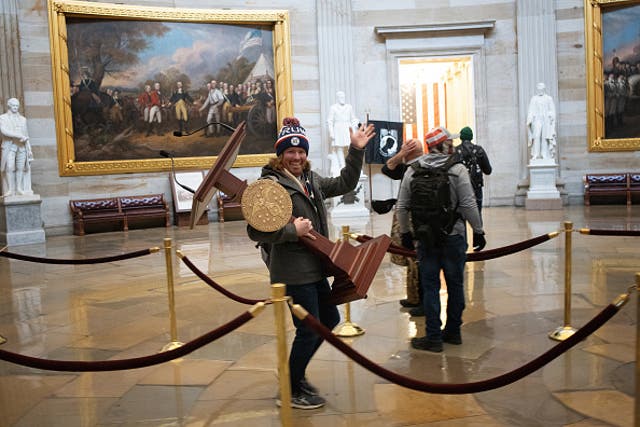 <p>Picture shows rioter carrying away the House speaker’s lectern&nbsp;</p>