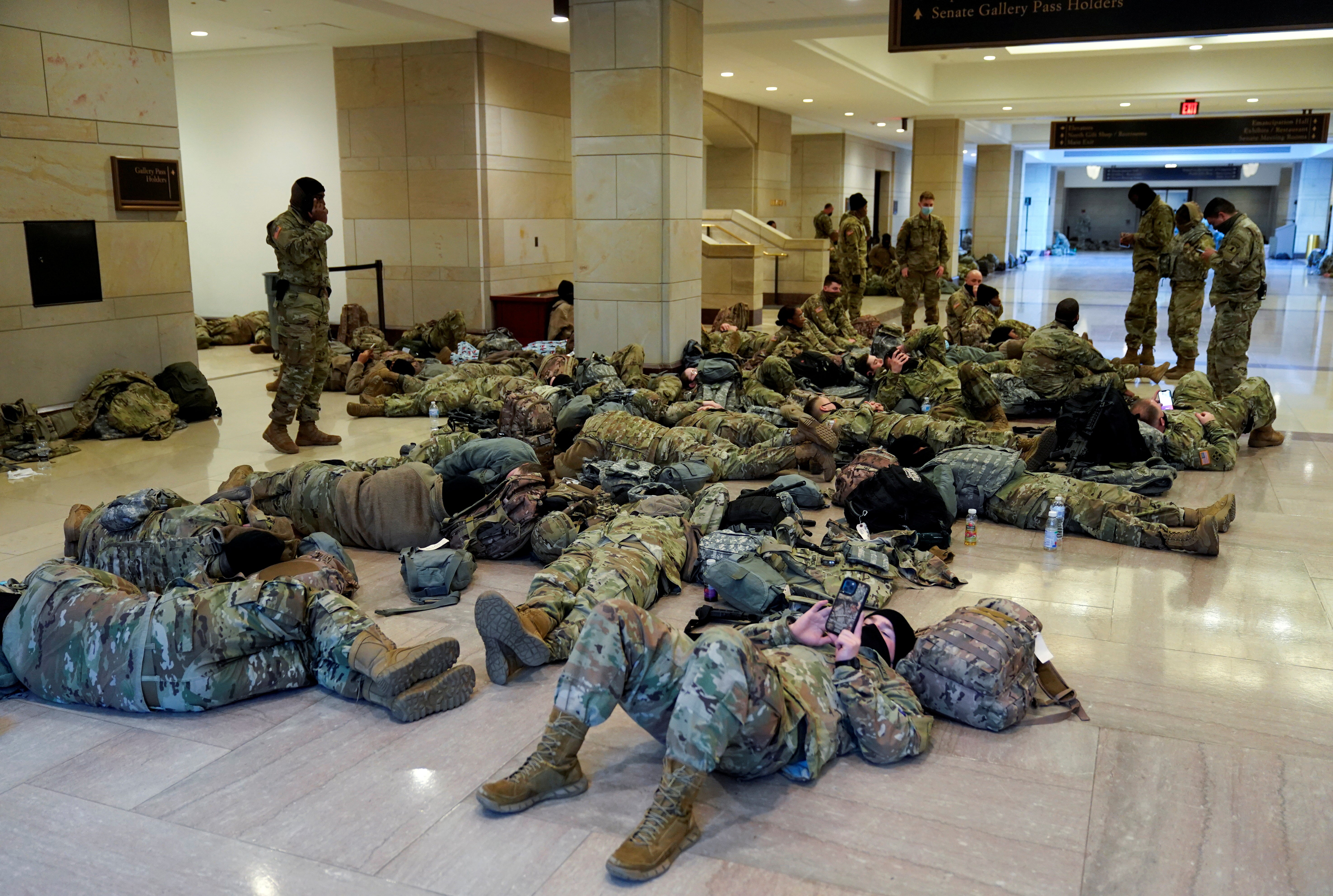 National Guard members sleep in the Capitol Visitor Centre before Democrats begin debating one article of impeachment against Donald Trump