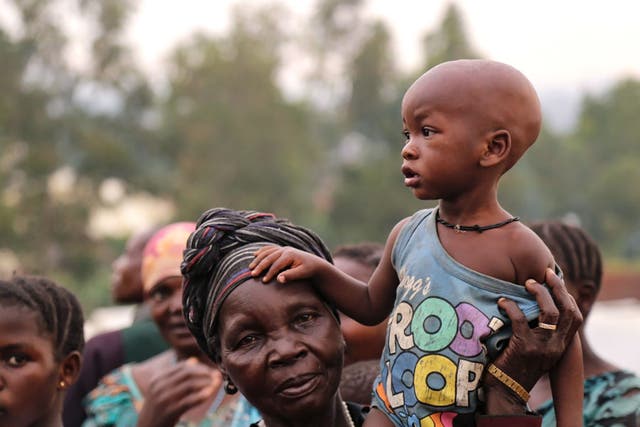 <p>A woman holds a child on her shoulders in an Internally Displaced Persons Camp outside the town of Bunia, in Ituri province.</p>