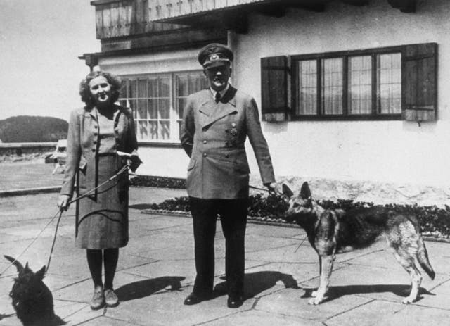 <p>Hitler with Eva Braun, his supposed wife, photographed with their dogs at Berchtesgaden</p>