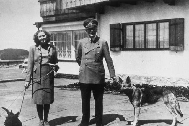 <p>Hitler with Eva Braun, his supposed wife, photographed with their dogs at Berchtesgaden</p>