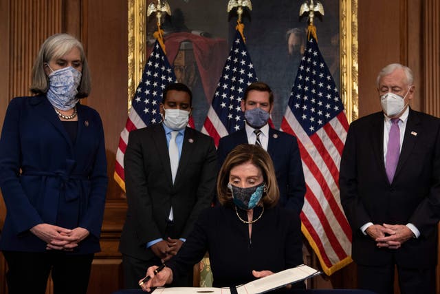 <p>Majority Leader Steny Hoyer (D-MD) (R) and Assistant Speaker Katherine Clark (D-MA) (L), alongside House Impeachment Managers (from L) Representatives Joe Neguse (D-CO) and Eric Swalwell (D-CA), look on as Speaker of the House Nancy Pelosi (D-CA) prepares to sign the article of impeachment during an engrossment ceremony after the US House of Representatives voted to impeach the US President Donald Trump at the US Capitol on 13 January 2021, in Washington, DC</p>
