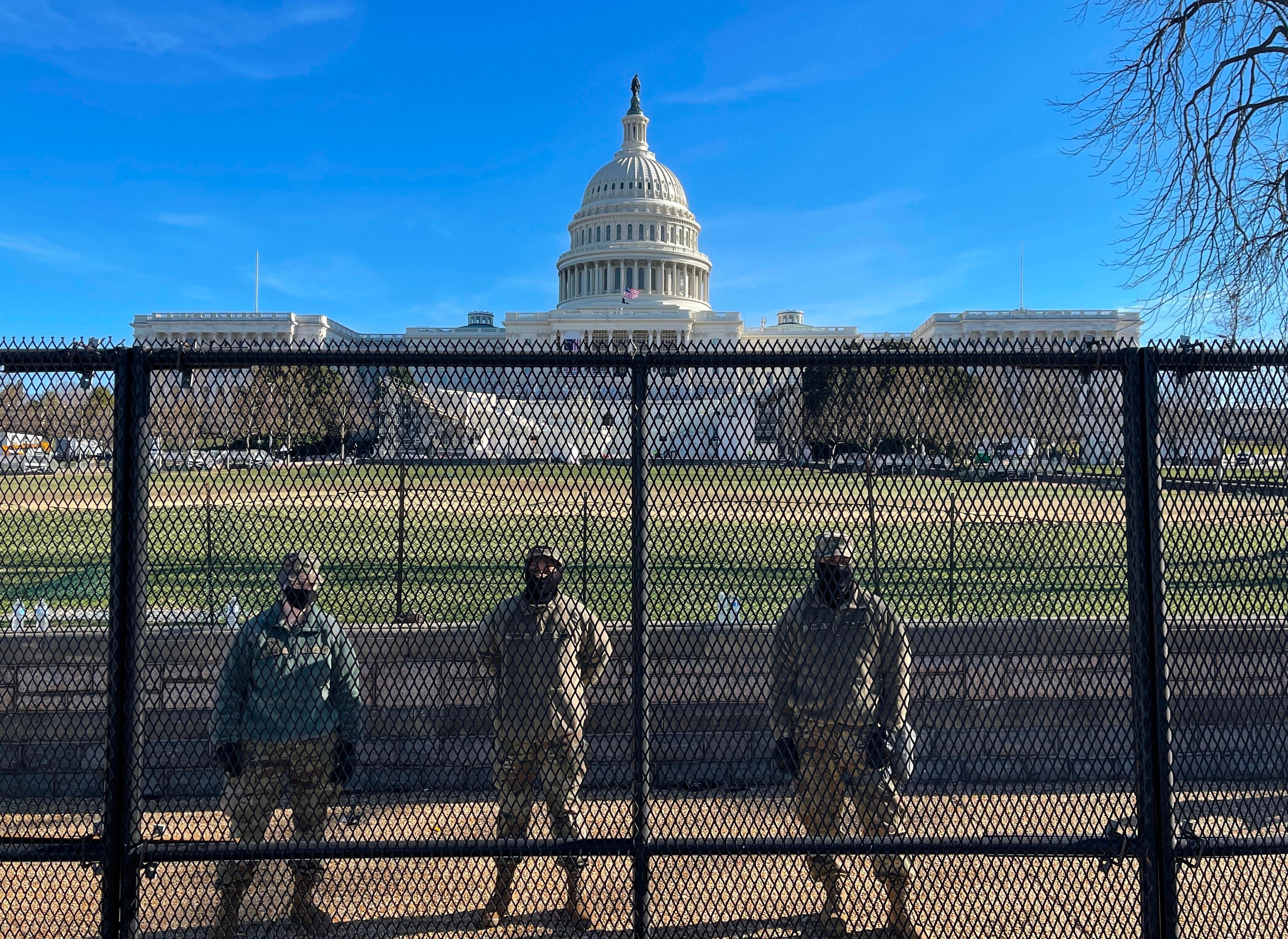 National Guard soldiers guard the grounds of the US Capitol from behind a security fence in Washington, DC