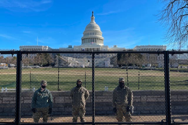 <p>National Guard soldiers guard the grounds of the US Capitol from behind a security fence in Washington, DC</p>
