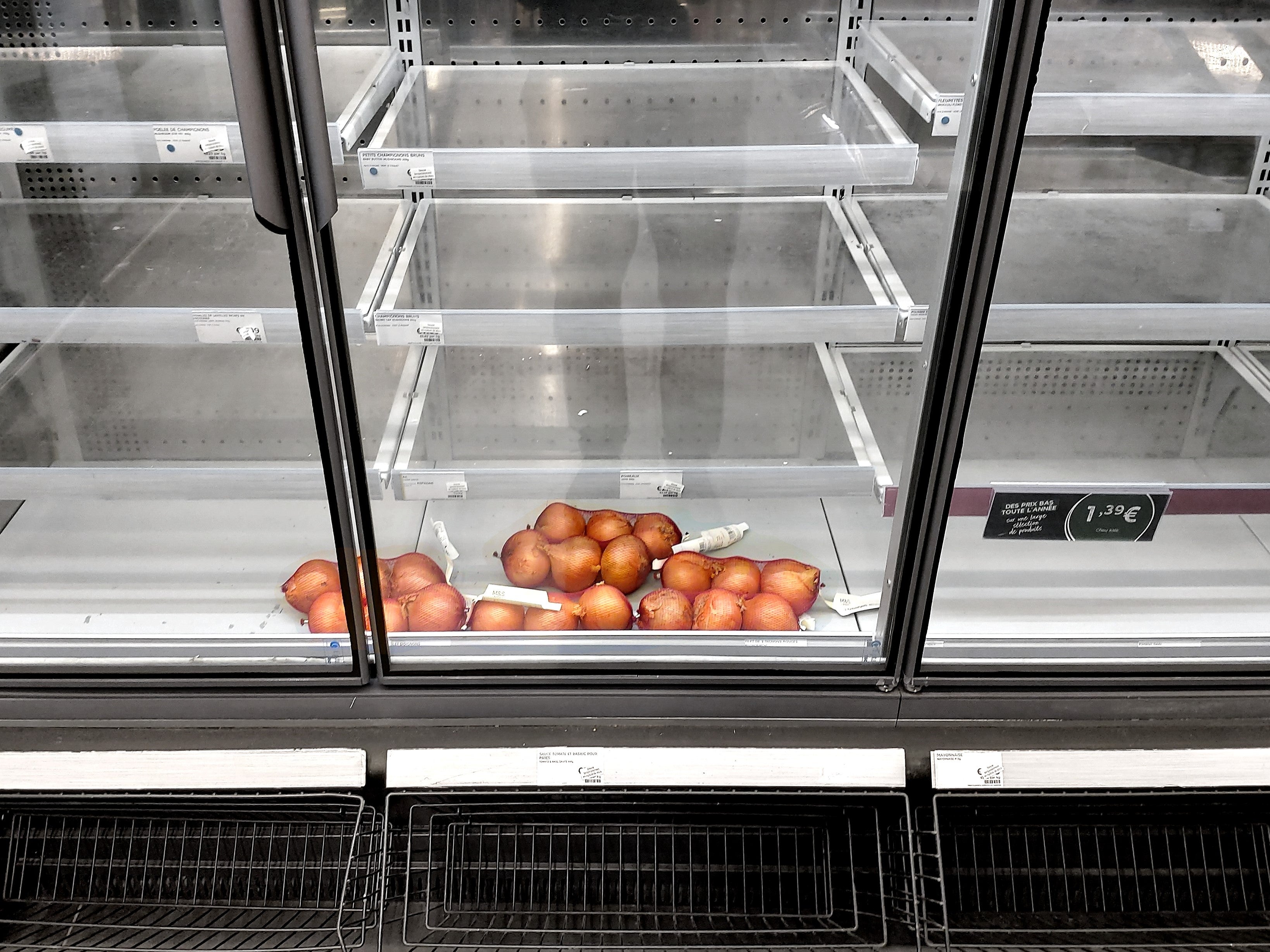 A few strings of onions are all that fills a chilled food section at Marks and Spencer on Boulevard Saint-Michel in Paris, 14 January, 2021