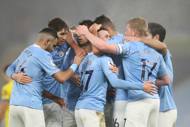 Manchester City players celebrate with a group embrace