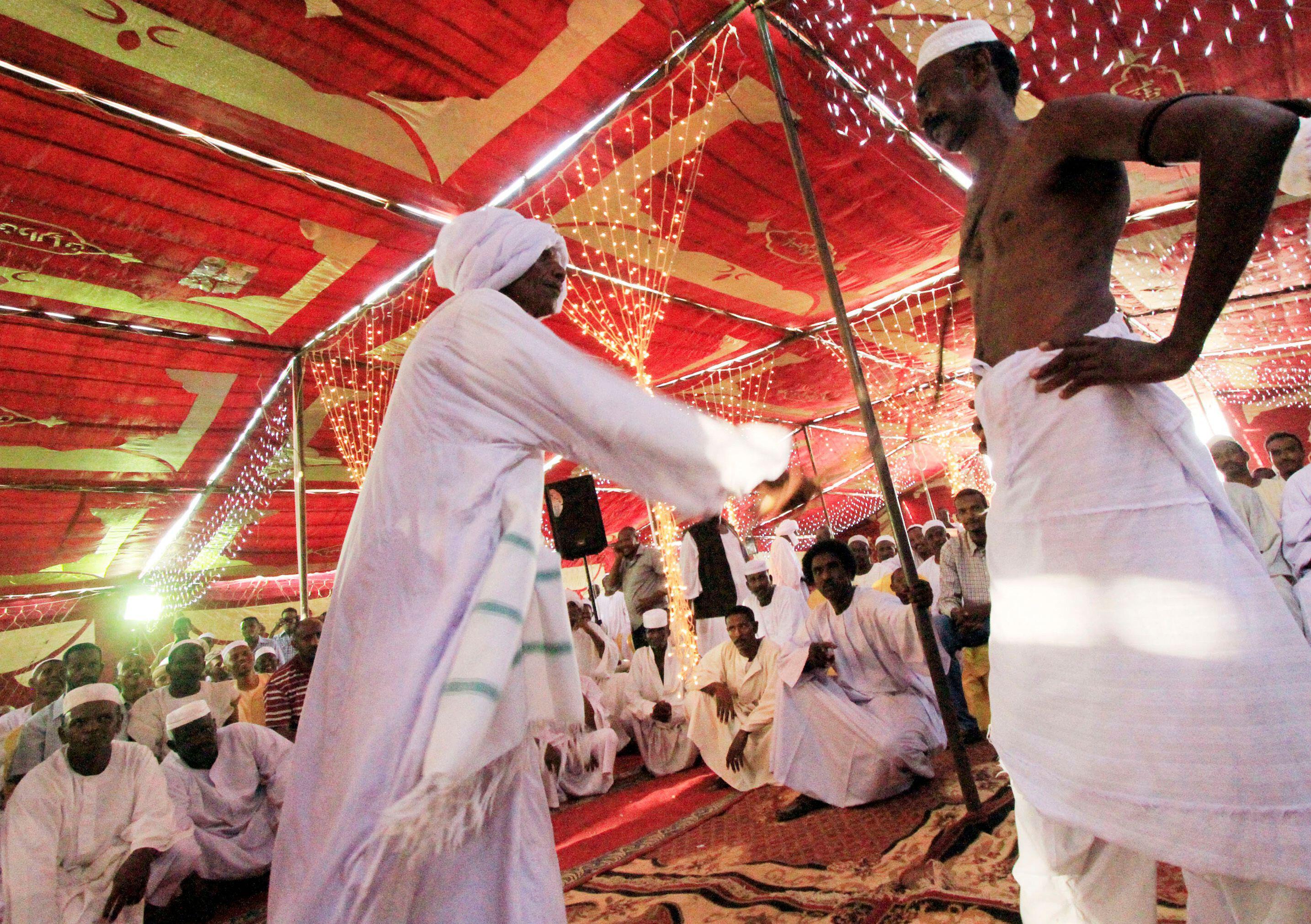 A man whips another during a traditional ceremony at a wedding
