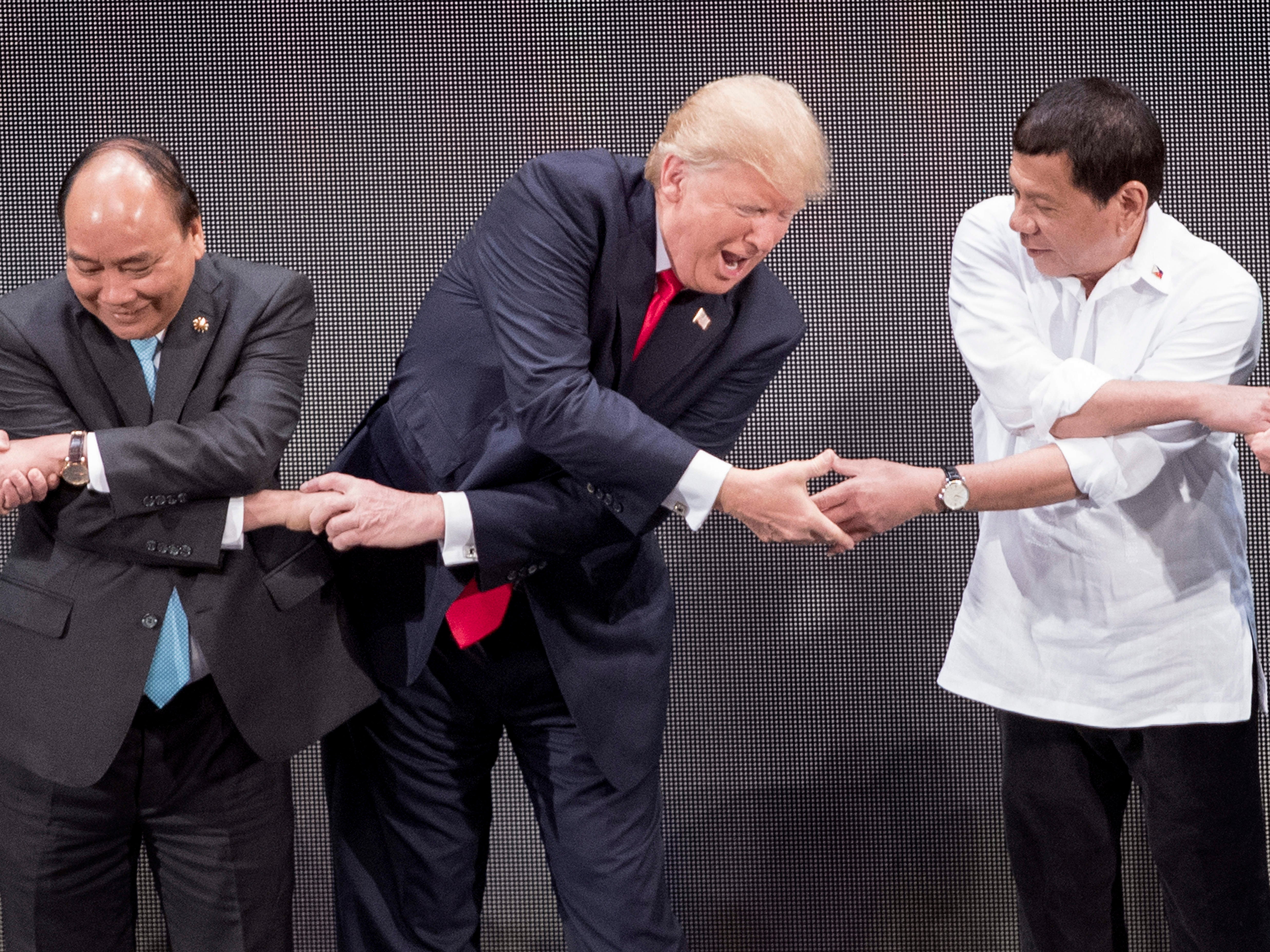 President Trump, Vietnam’s Prime Minister Nguyen Xuan Phuc and Philippine President Rodrigo Duterte join hands for the family photo during the 31st Association of South East Asian Nations, 13 November 2017
