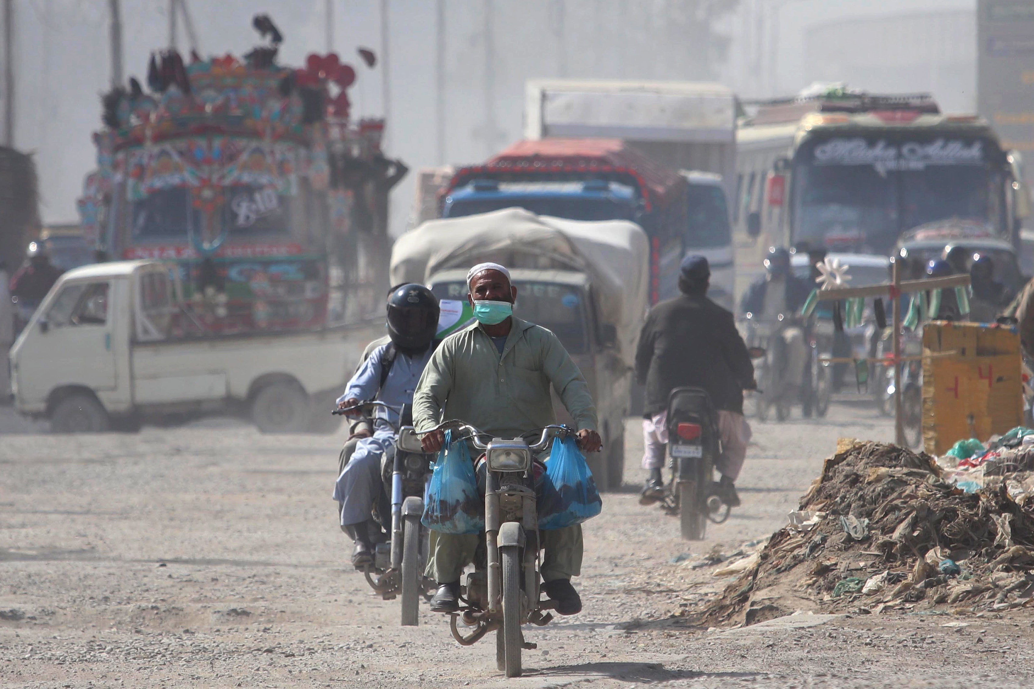 A man wears a face mask as he rides a motorcycle amid the ongoing COVID-19 pandemic in Pakistan
