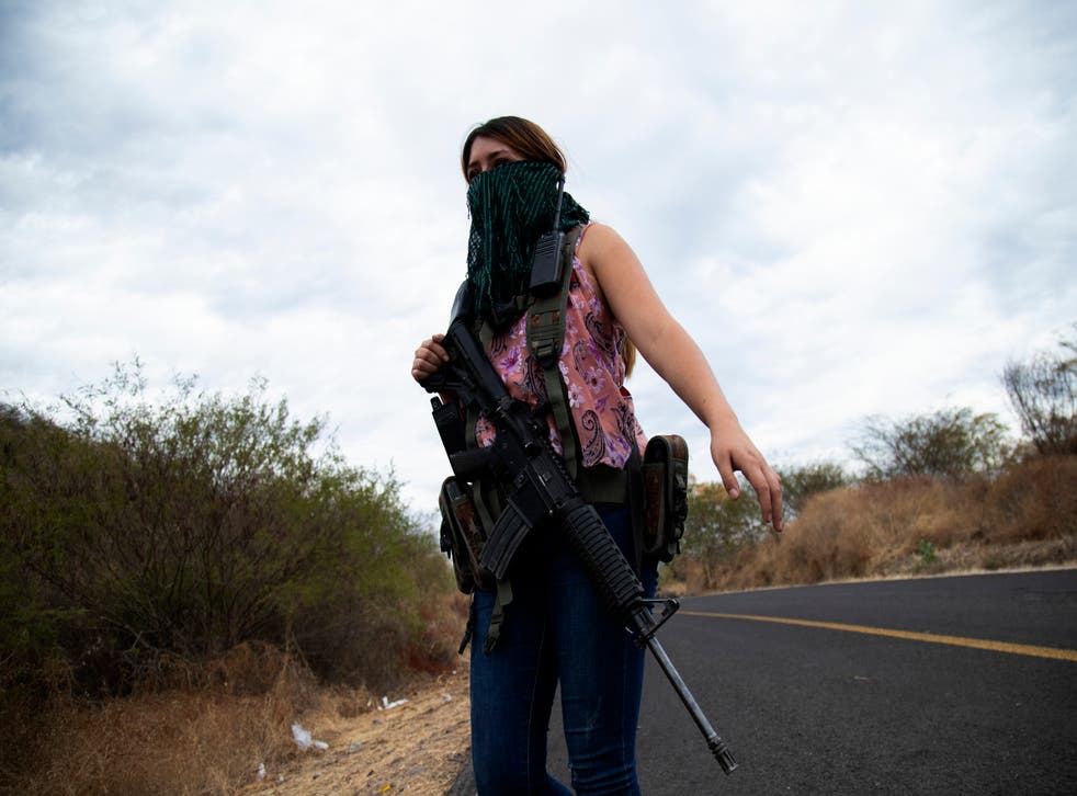 <p>Una mujer armada vigila las afueras de El Terrero, en el estado de Michoacán, México, el jueves 14 de enero de 2021. </p>