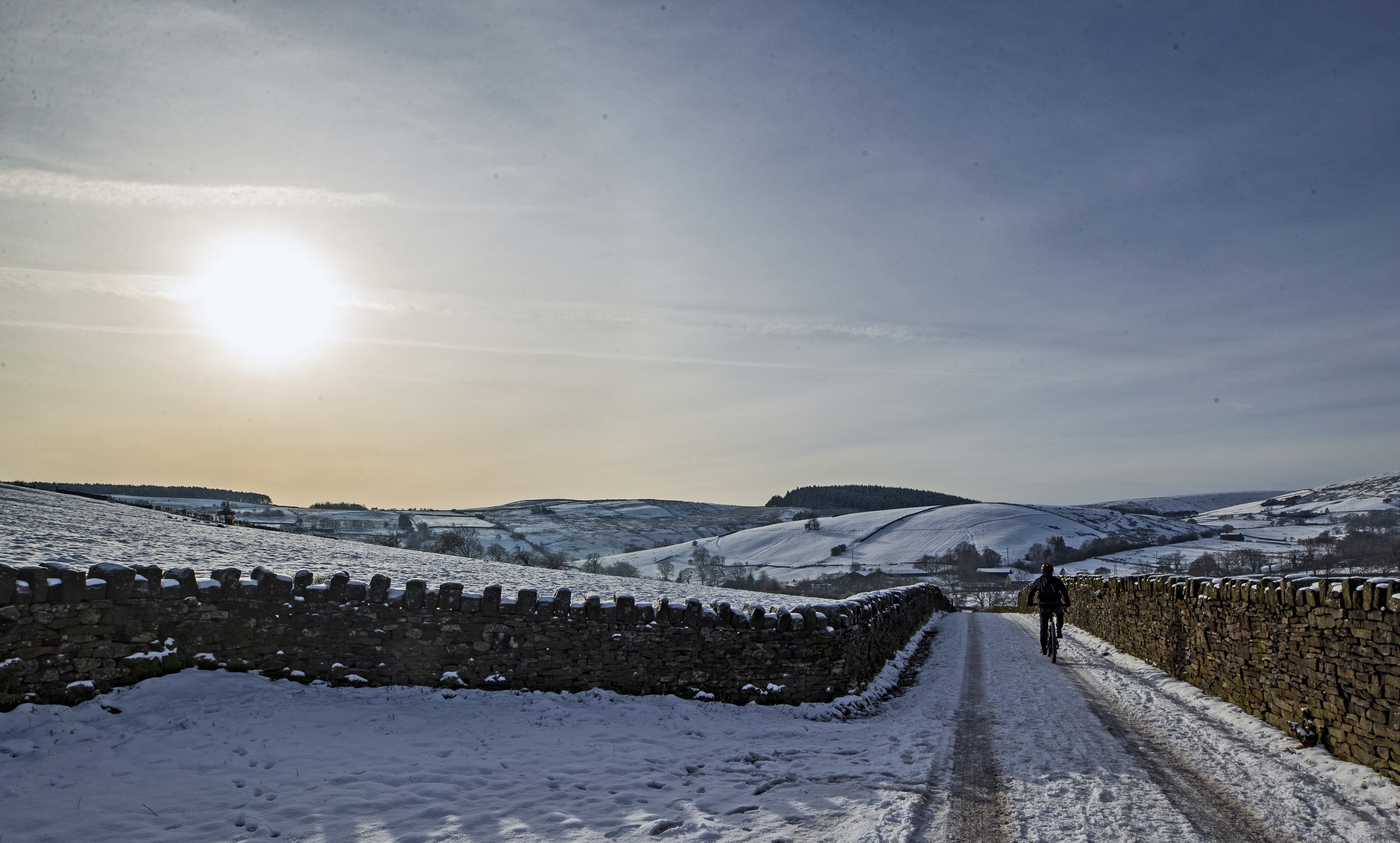 A cyclist on the snow at Blackmoss Reservoir in Barley, Pendle, Lancashire.