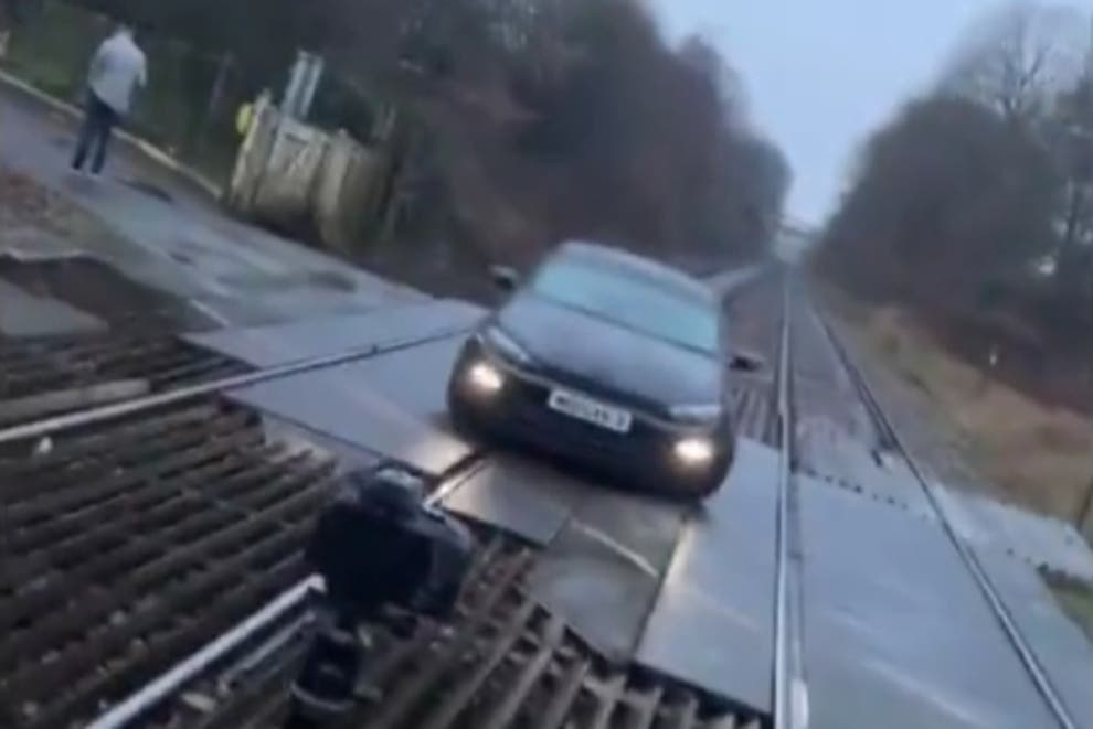 A still from the video of a car parked at a level crossing in Bolton