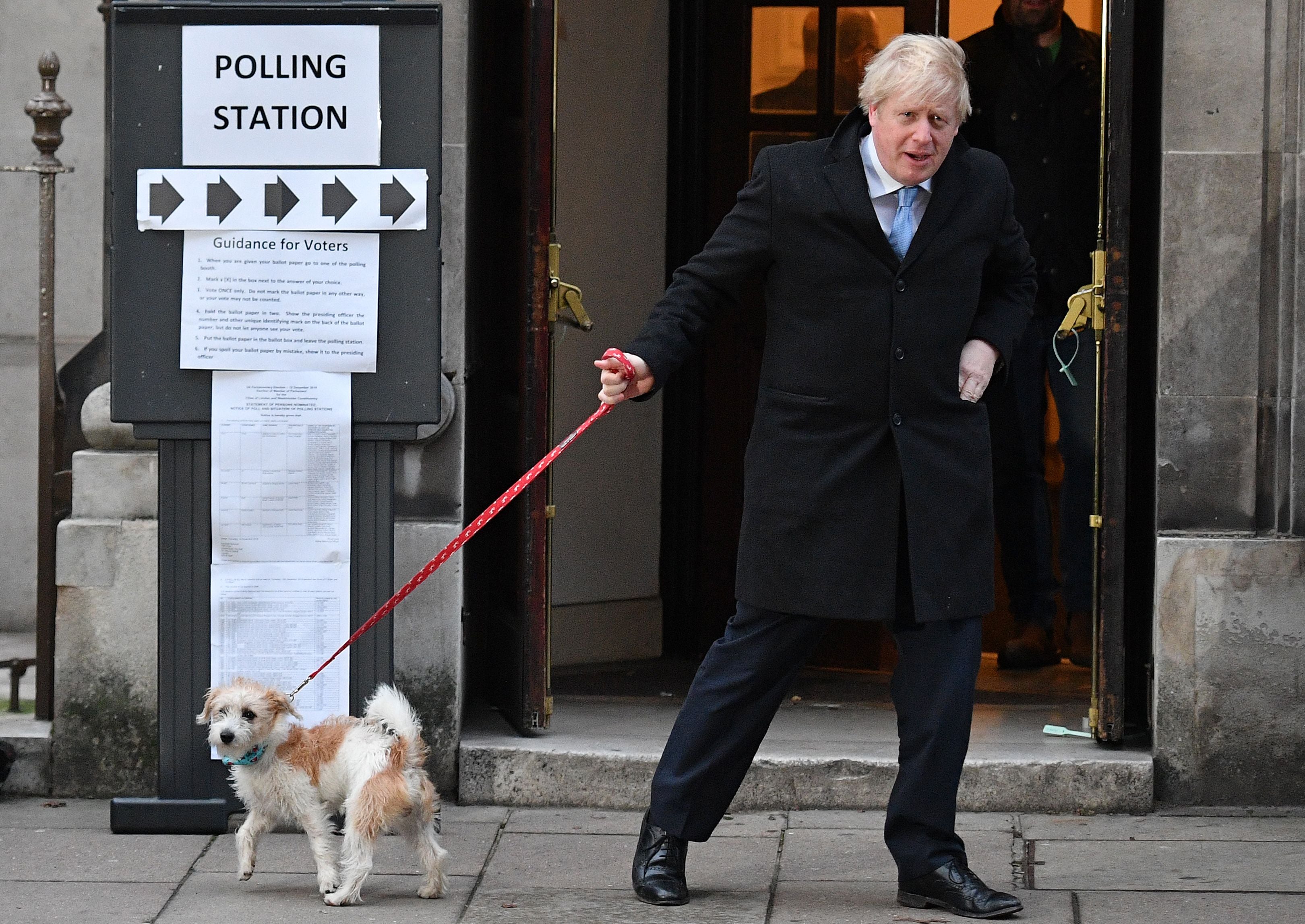 Boris Johnson and his dog Dilyn leave a polling station, after he cast his ballot paper, in 2019
