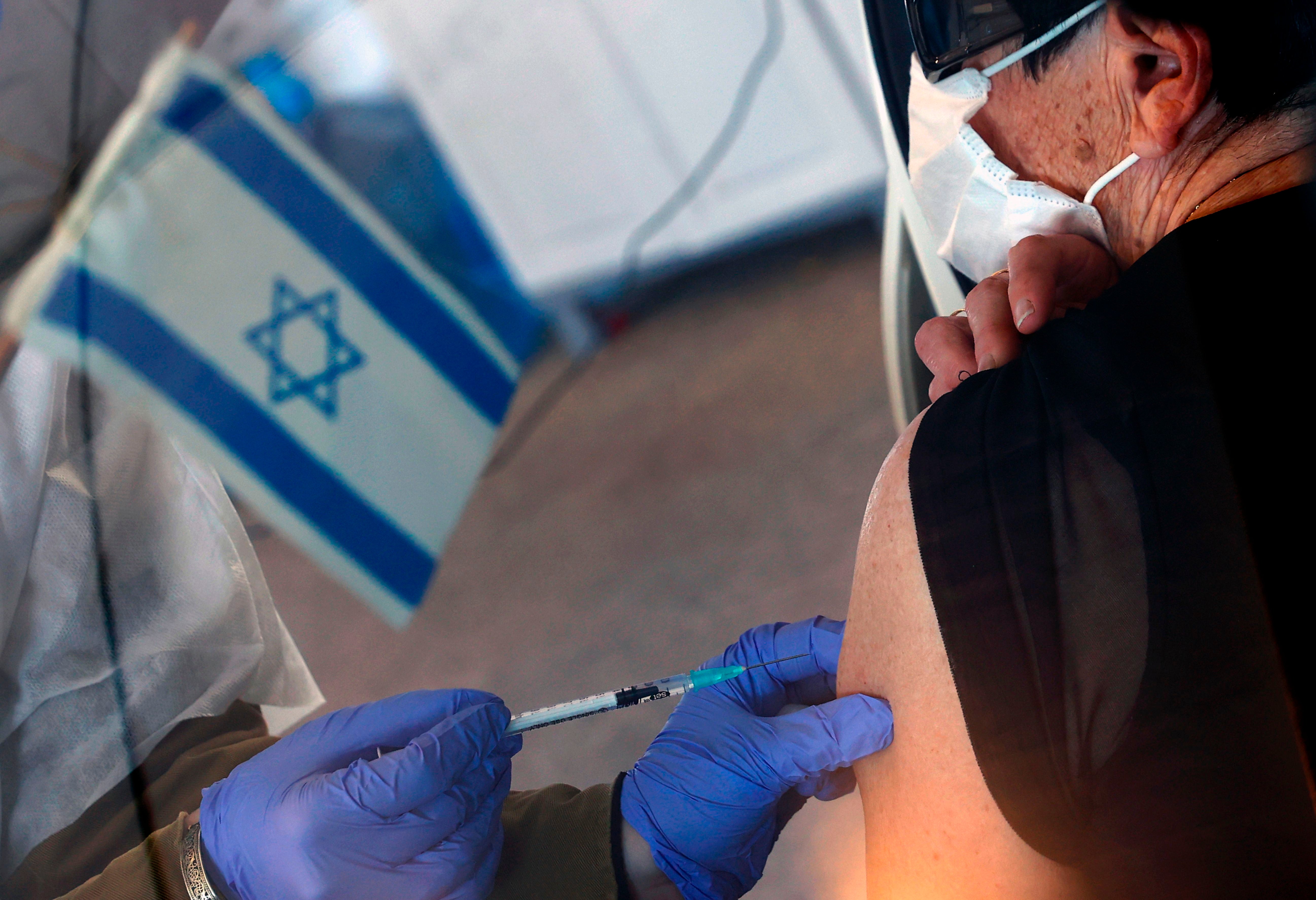 An Israeli senior citizen receives her second Pfizer Covid vaccine at the Maccabi Health Services drive-in vaccination center, in the northern coastal city of Haifa