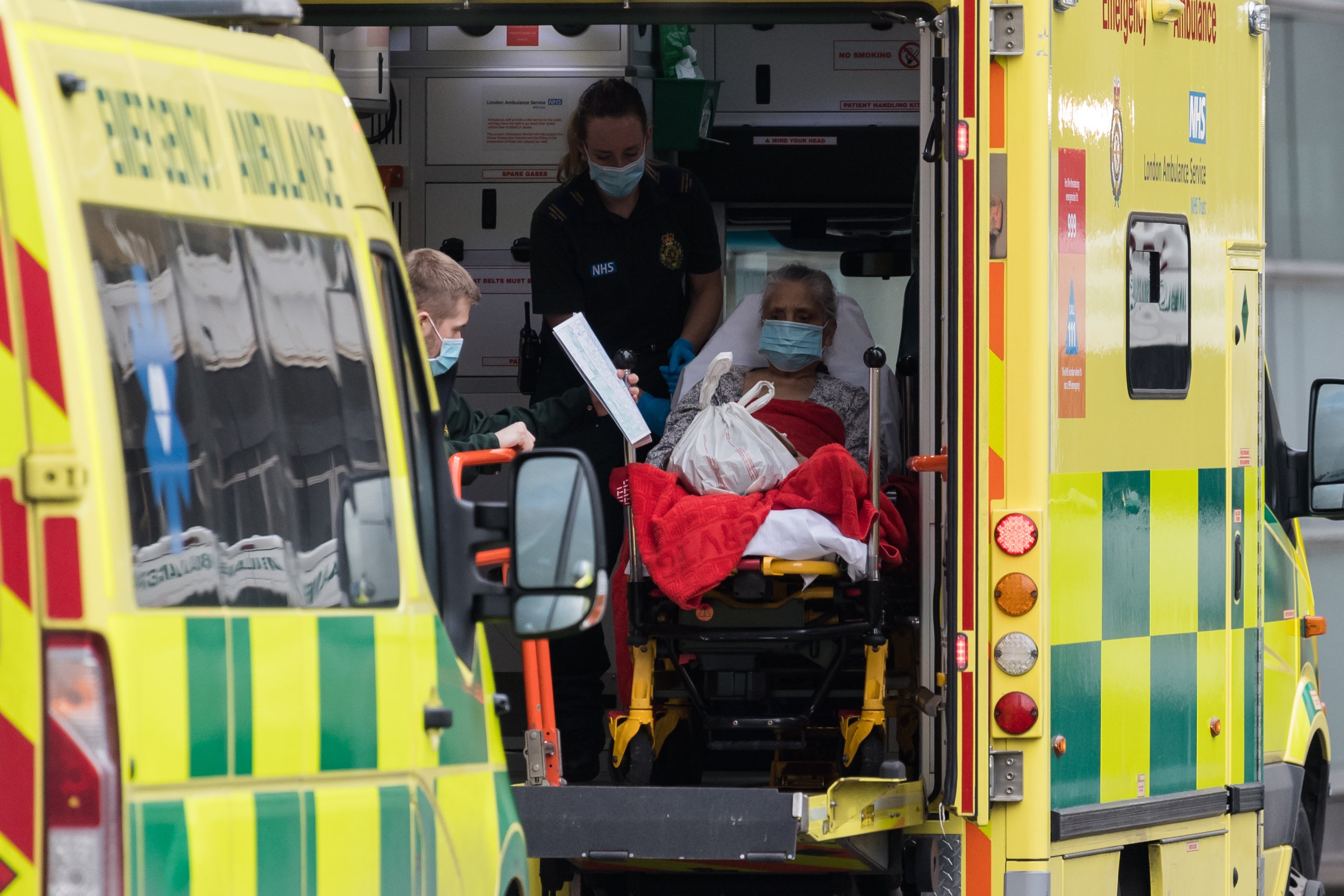 <p>Paramedics transport a patient in London</p>