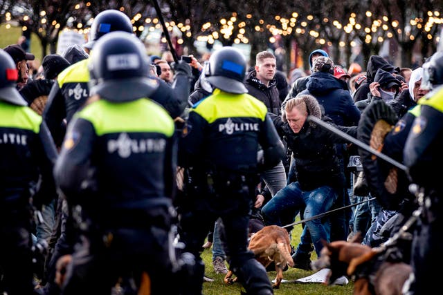 <p>Demonstrators face Dutch police at the Museumplein, in Amsterdam, on January 17, 2021</p>