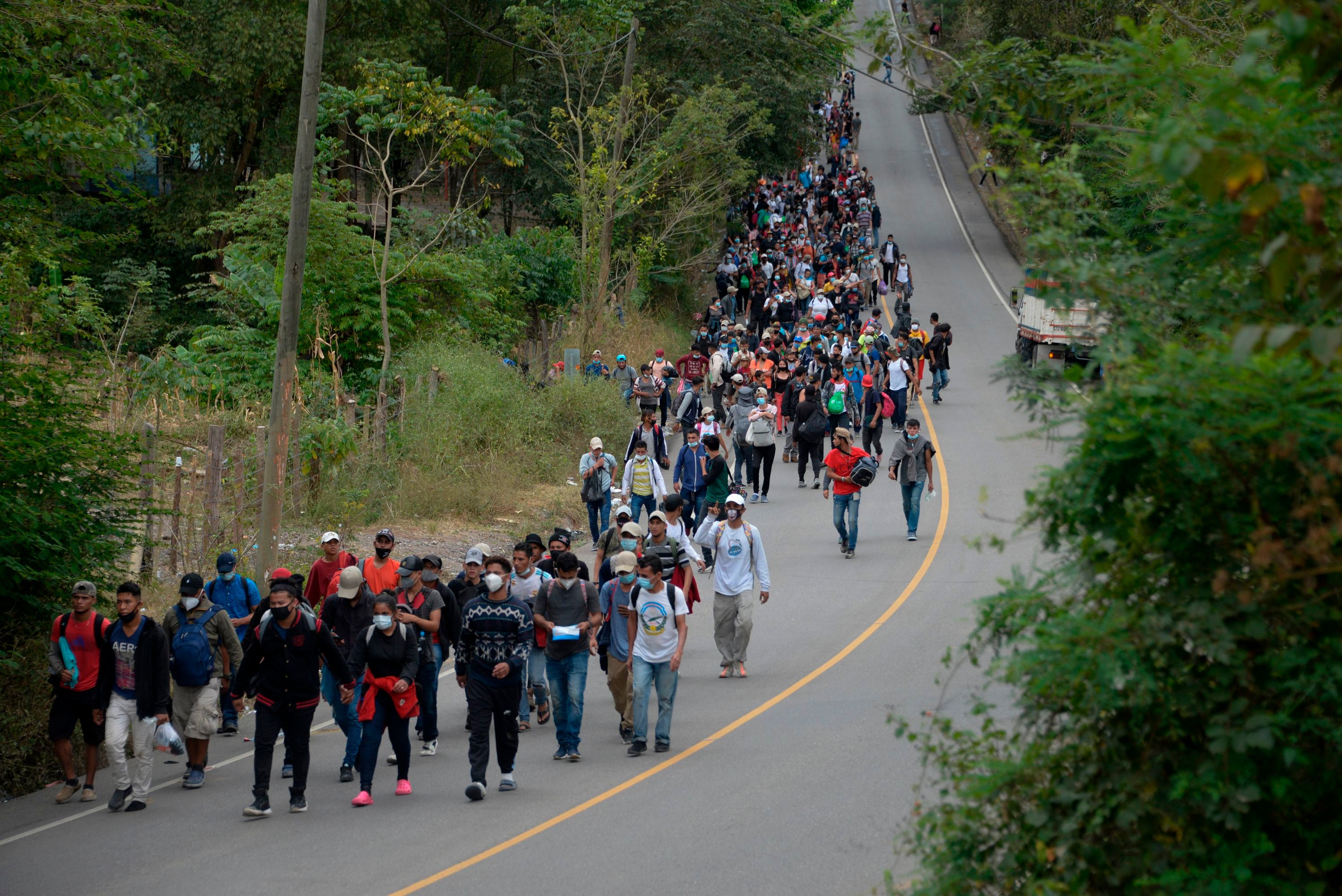 Honduran migrants, part of a caravan heading to the United States, walk along a road in Camotan, Guatemala on 16 January, 2021.