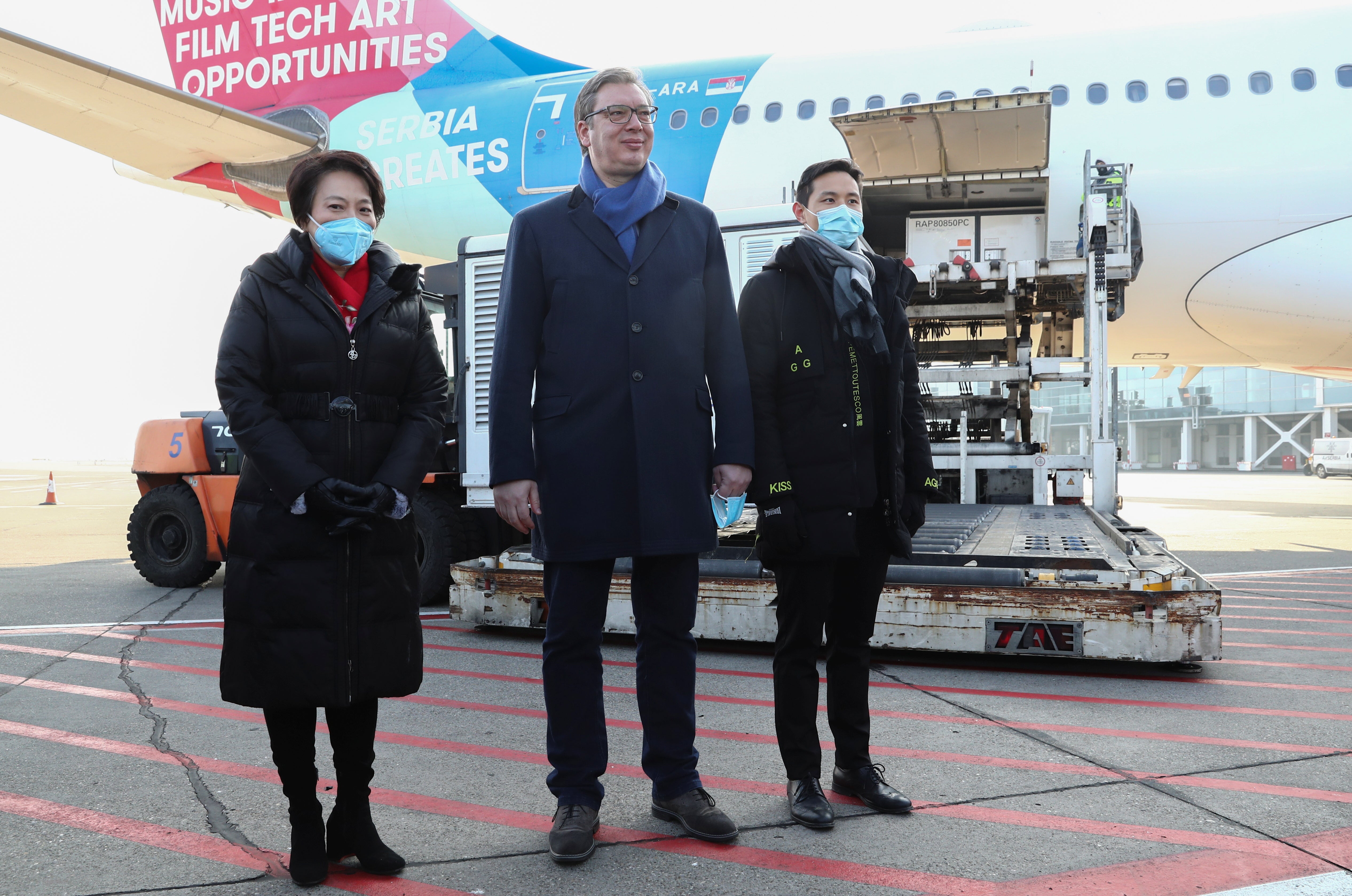 Serbian President Aleksandar Vucic (pictured centre) await the arrival of the Chinese Covid-19 vaccine on Saturday