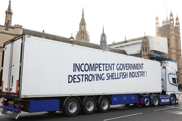  A lorry featuring a message accusing the government of incompetence passes in front of the Houses of Parliament to protest on Monday