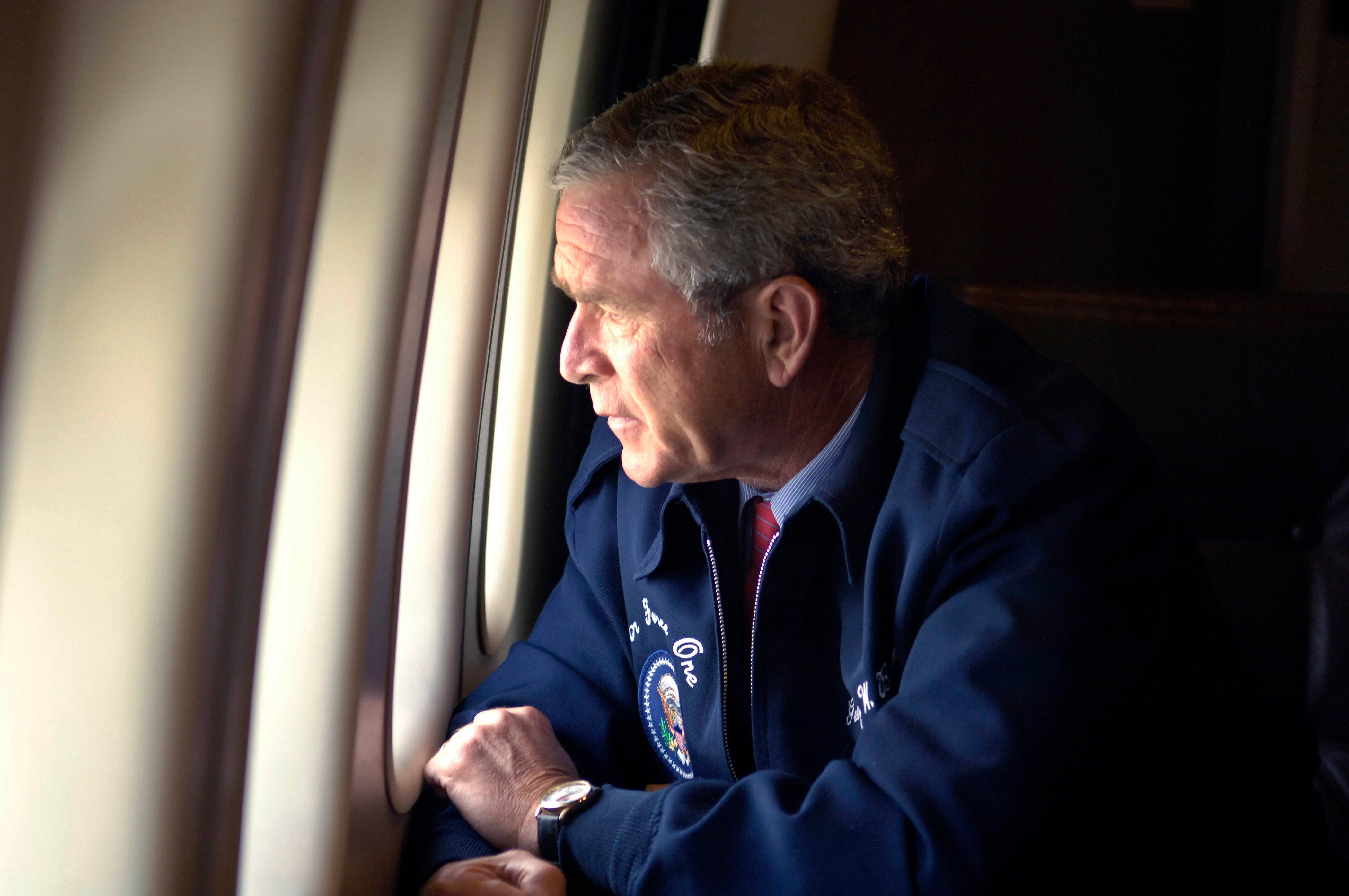 George Bush peers out the window of Air Force One as he surveys Hurricane Katrina damage along the Gulf Coast states of Louisiana, Mississippi and Alabama