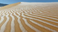 Unusual snowfall in the Sahara desert leaves patterns in the dunes