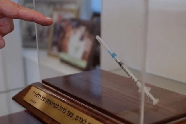 <p>La jeringa está sobre una base de madera al interior de la oficina de Netanyahu</p>