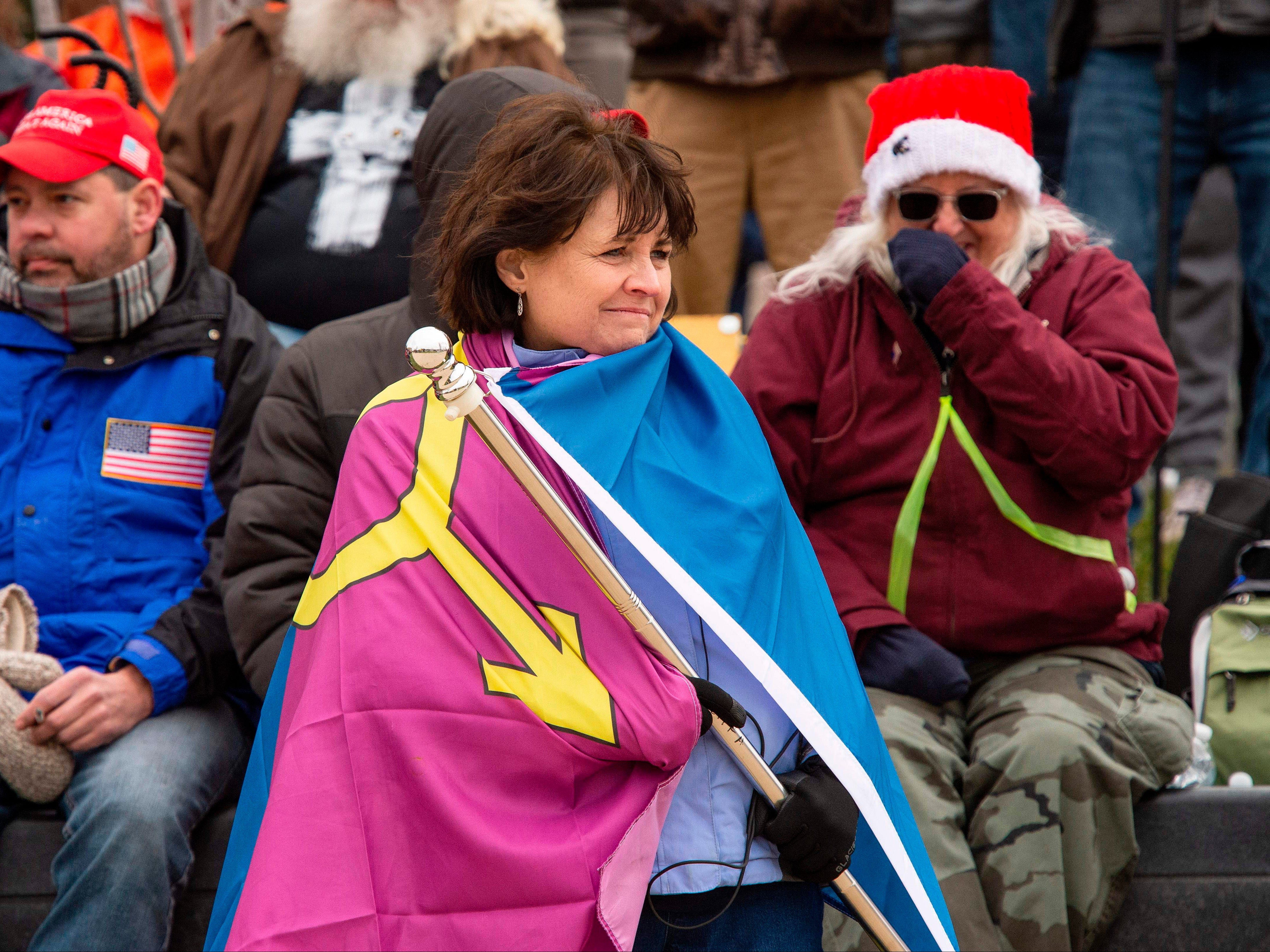 <p>“Super Fun Happy America’s” Sue Ianni wraps herself in the group’s “Straight Pride” flag as she and other supporters of US President Donald Trump wait for him to address them during a rally in Washington, DC on 6 January 2021</p>