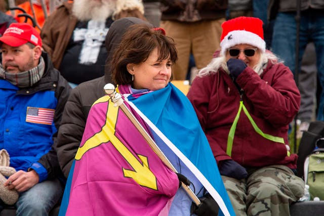 <p>“Super Fun Happy America’s” Sue Ianni wraps herself in the group’s “Straight Pride” flag as she and other supporters of US President Donald Trump wait for him to address them during a rally in Washington, DC on 6 January 2021</p>