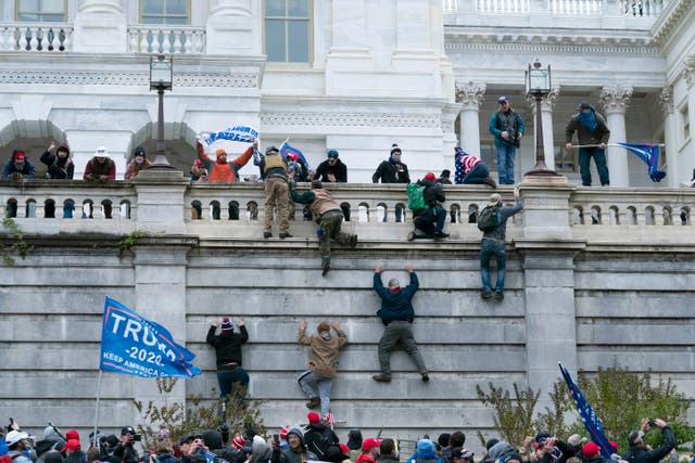 <p>FILE - In this Wednesday, Jan. 6, 2021 file photo, supporters of President Donald Trump scale the west wall of the the U.S. Capitol in Washington.&nbsp;</p>