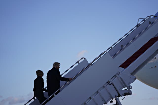 El presidente Donald Trump (derecha) y la primera dama de Estados Unidos, Melania Trump, abordan el Air Force One durante una ceremonia de despedida en la base conjunta Andrews, Maryland