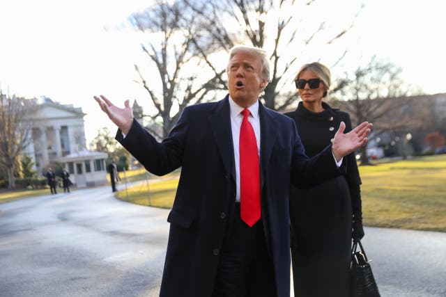 Donald Trump hace un gesto mientras él y la primera dama Melania Trump salen de la Casa Blanca para abordar el Marine One