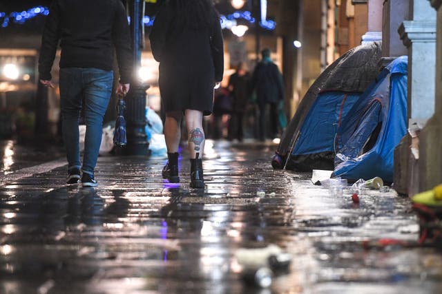 En diciembre, se ve a personas caminando frente a las tiendas de campaña de personas sin hogar en Londres. El número de nuevos durmientes ha aumentado en Londres este año en medio de la agitación económica causada por la pandemia.