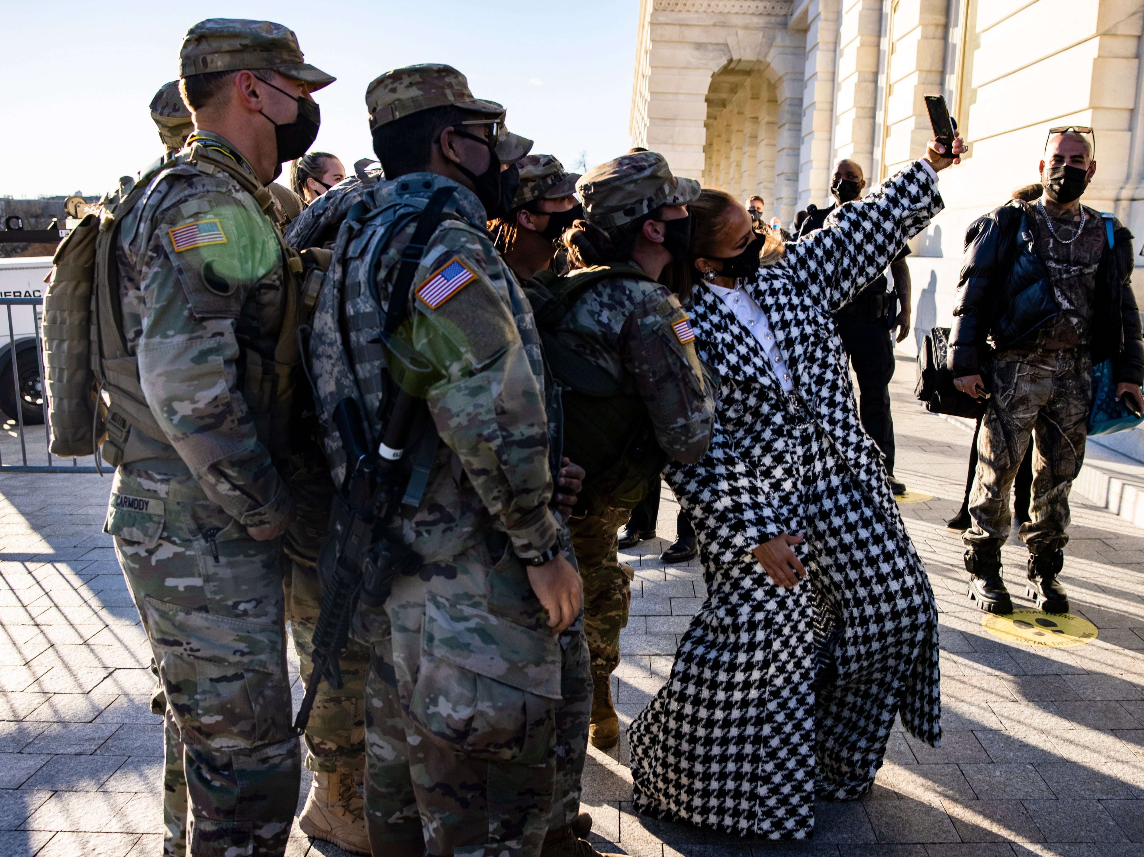 Jennifer Lopez stops to take a selfie with a group fo Maryland National Guard soldiers as she leaves the US Capitol building