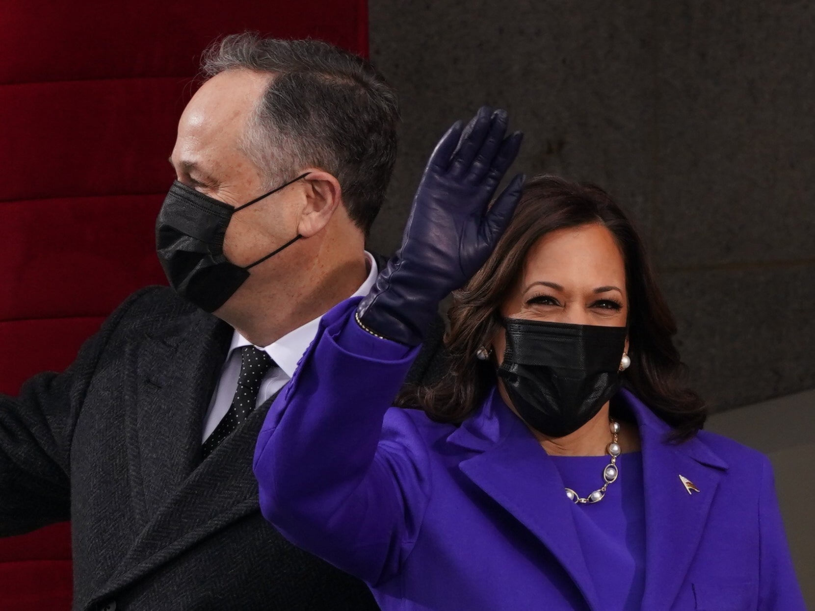 Vice-president elect Kamala Harris and her husband Doug Emhoff wave as they make their entrance to the inaugural ceremony on the West Front of the Capitol
