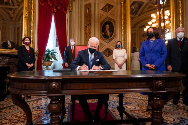 Joe Biden, watched by Kamala Harris, signs first orders as president