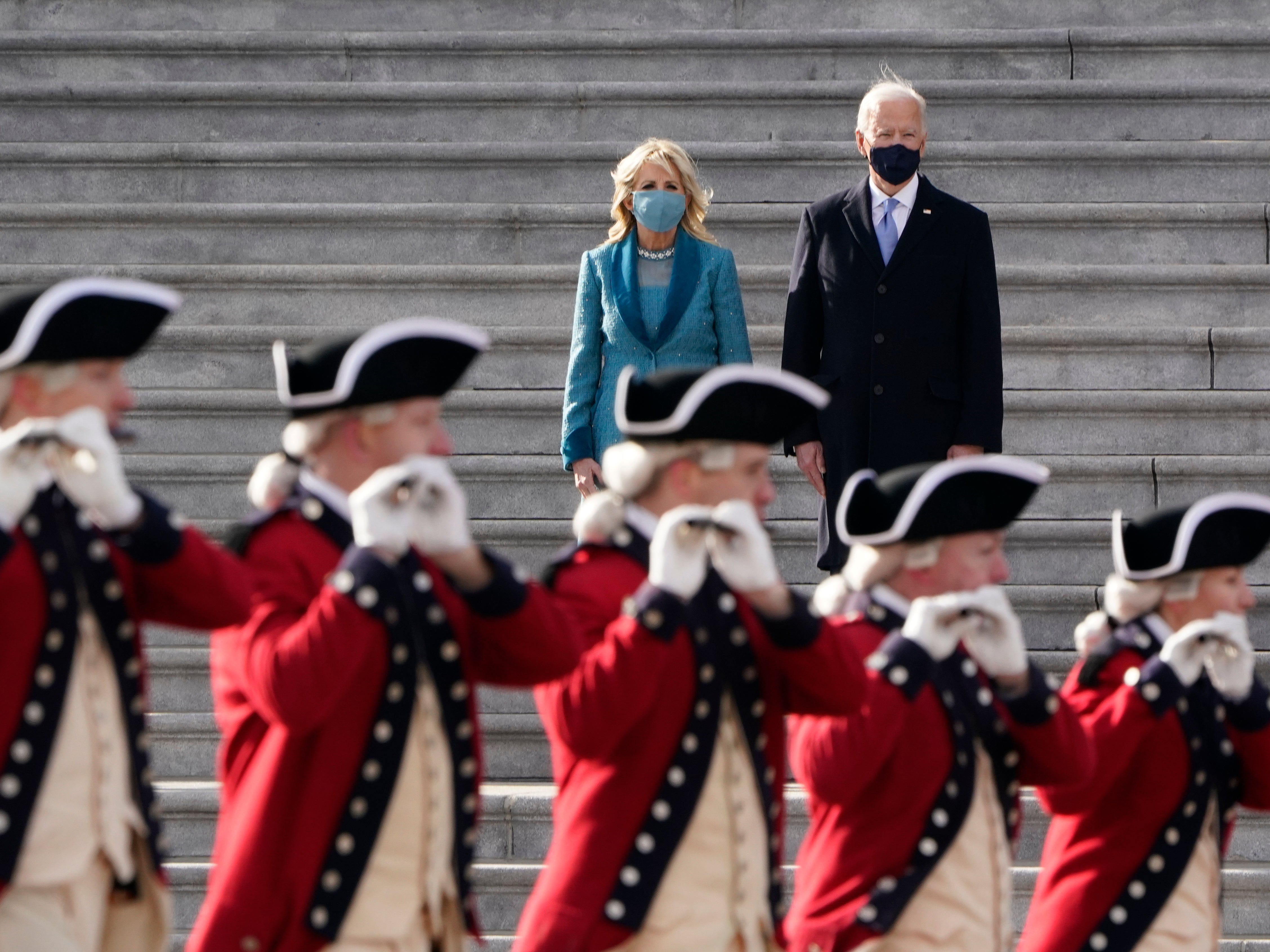 Joe Biden and his wife Jill Biden watch a military pass in review ceremony on the East Front of the Capitol at the conclusion of the inauguration ceremonies