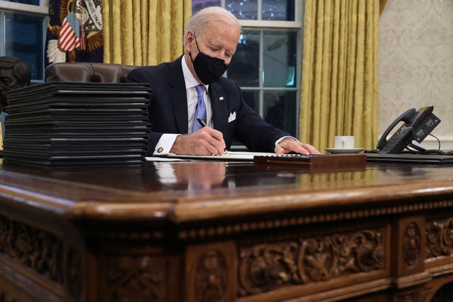 <p>President Joe Biden sitting at the Resolute desk in the White House just hours after taking office in January 2021 </p>