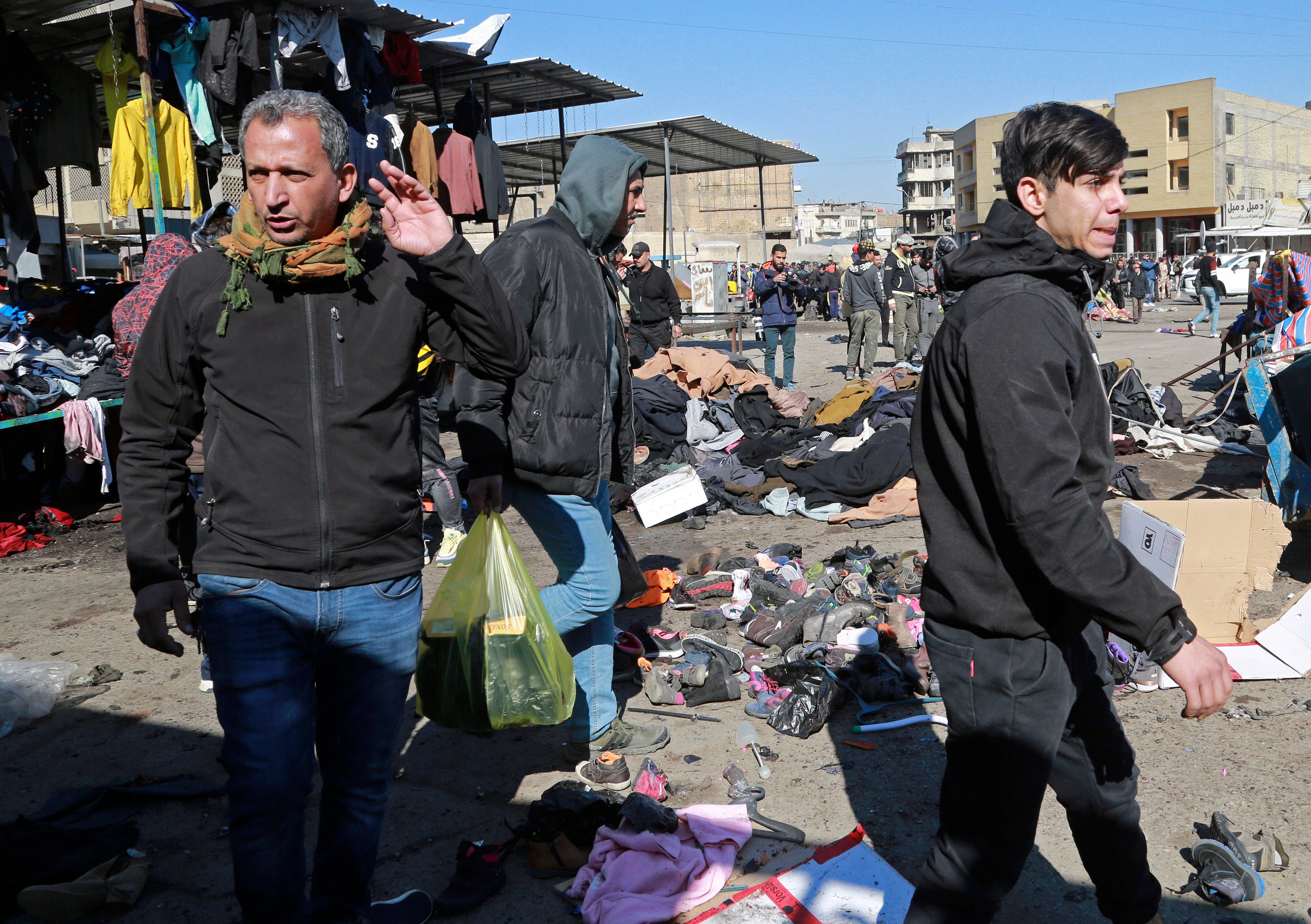 People and security forces gather at the site of a deadly bomb attack in Baghdad