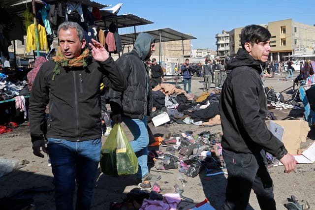Personas y fuerzas de seguridad se reúnen en el lugar de un mortal atentado con bomba en Bagdad