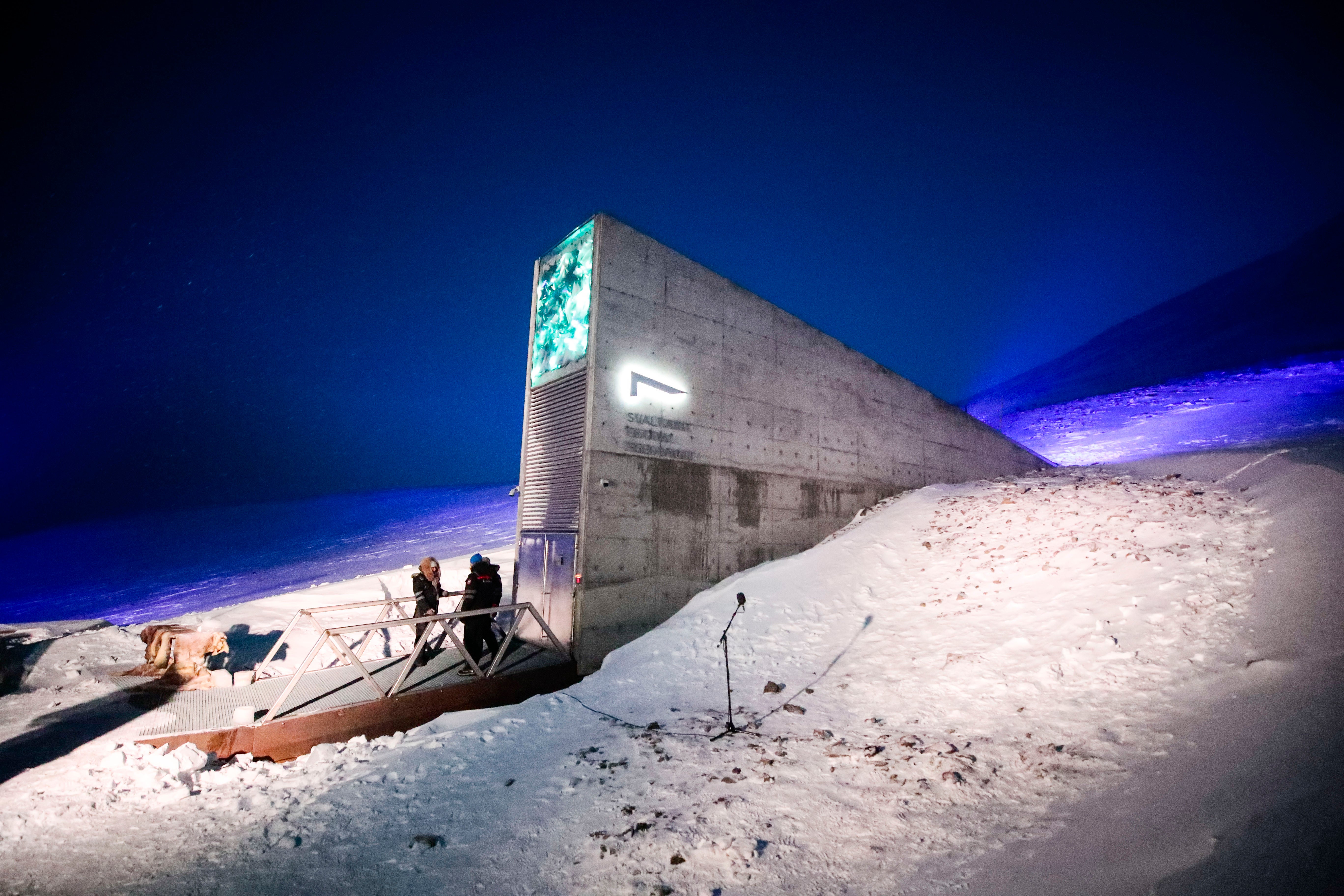 People stand in front of the entrance to the international gene bank Svalbard Global Seed Vault (SGSV)