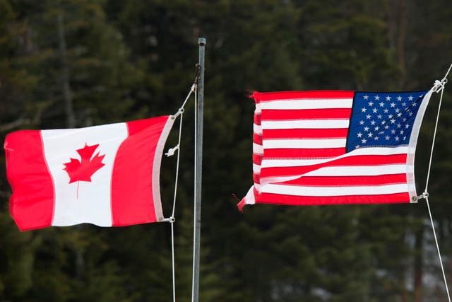 <p>Canadian and American flags are seen at the US/Canada border on 1 March 2017, in Pittsburg, New Hampshire</p>