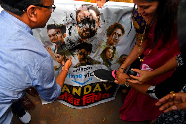 <p>Supporters of India's ruling Bharatiya Janata Party (BJP) pour ink and beat a poster with footwear during a protest against a new web series 'Tandav', in Mumbai on 18 January 2021</p>