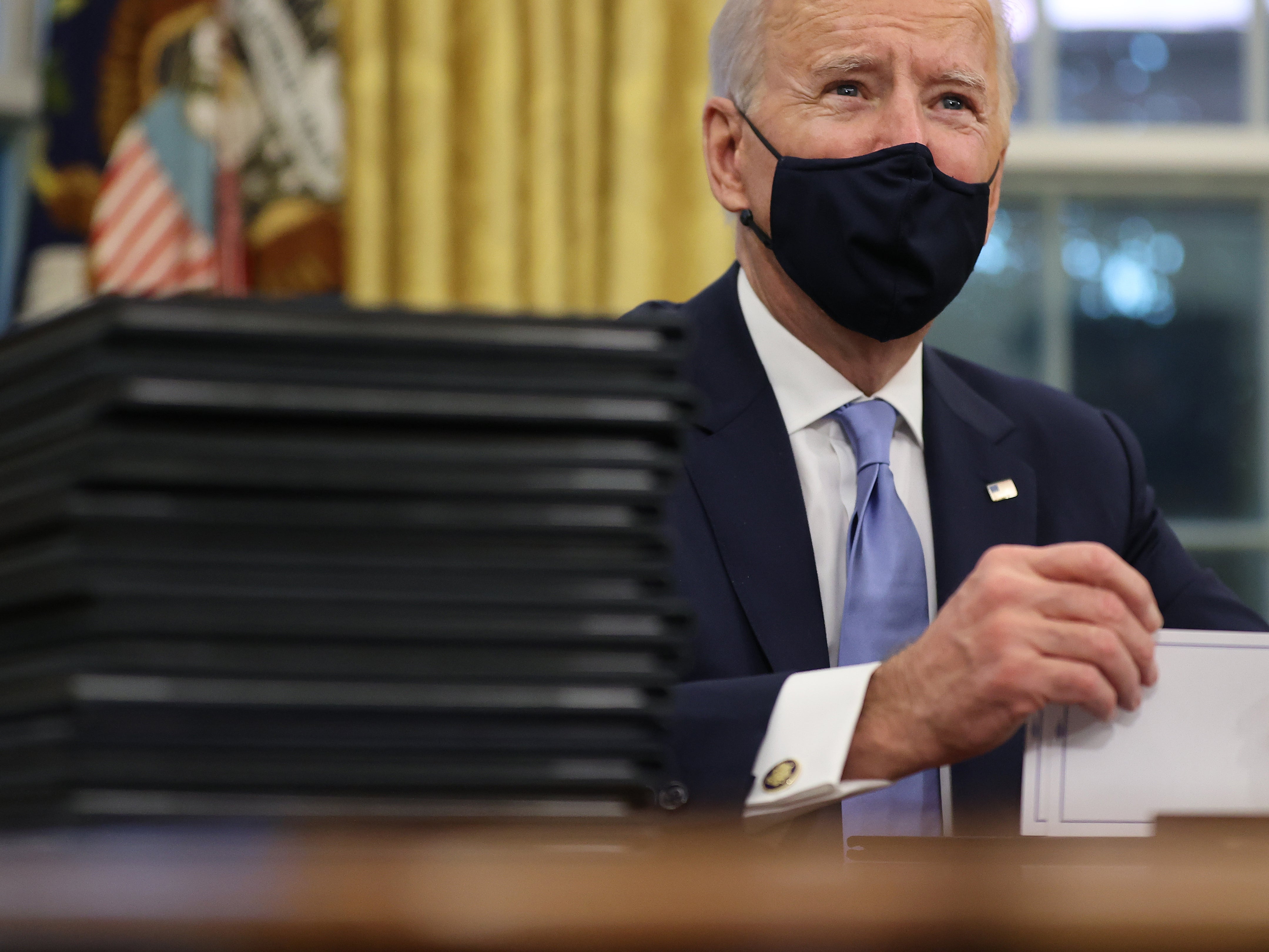 US President Joe Biden prepares to sign a series of executive orders at the Resolute Desk in the Oval Office just hours after his inauguration on 20 January, 2021