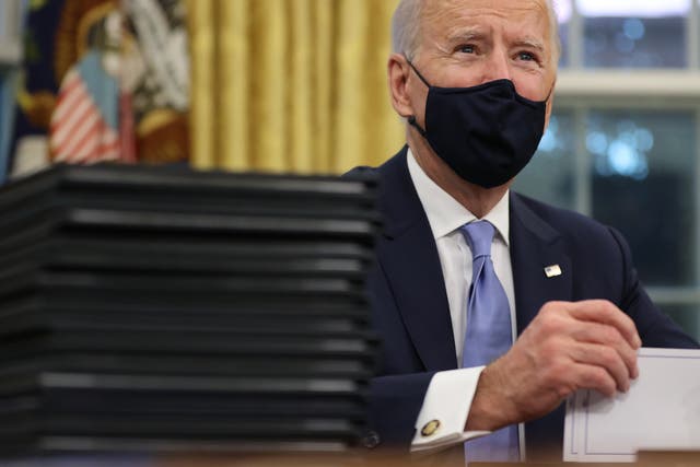 <p>Joe Biden prepares to sign a series of executive orders at the Resolute Desk in the Oval Office just hours after his inauguration on 20 January, 2021</p>
