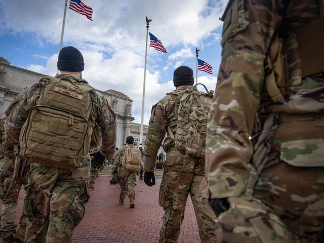 <p>Members of the National Guard march by Union Station during the inauguration of Joe Biden as US President in Washington, DC, on 20 January 2021</p>
