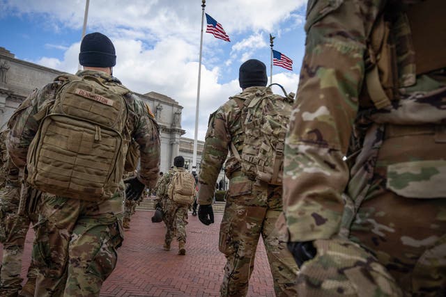 <p>Members of the National Guard march by Union Station during the inauguration of Joe Biden as US President in Washington, DC, on 20 January 2021</p>