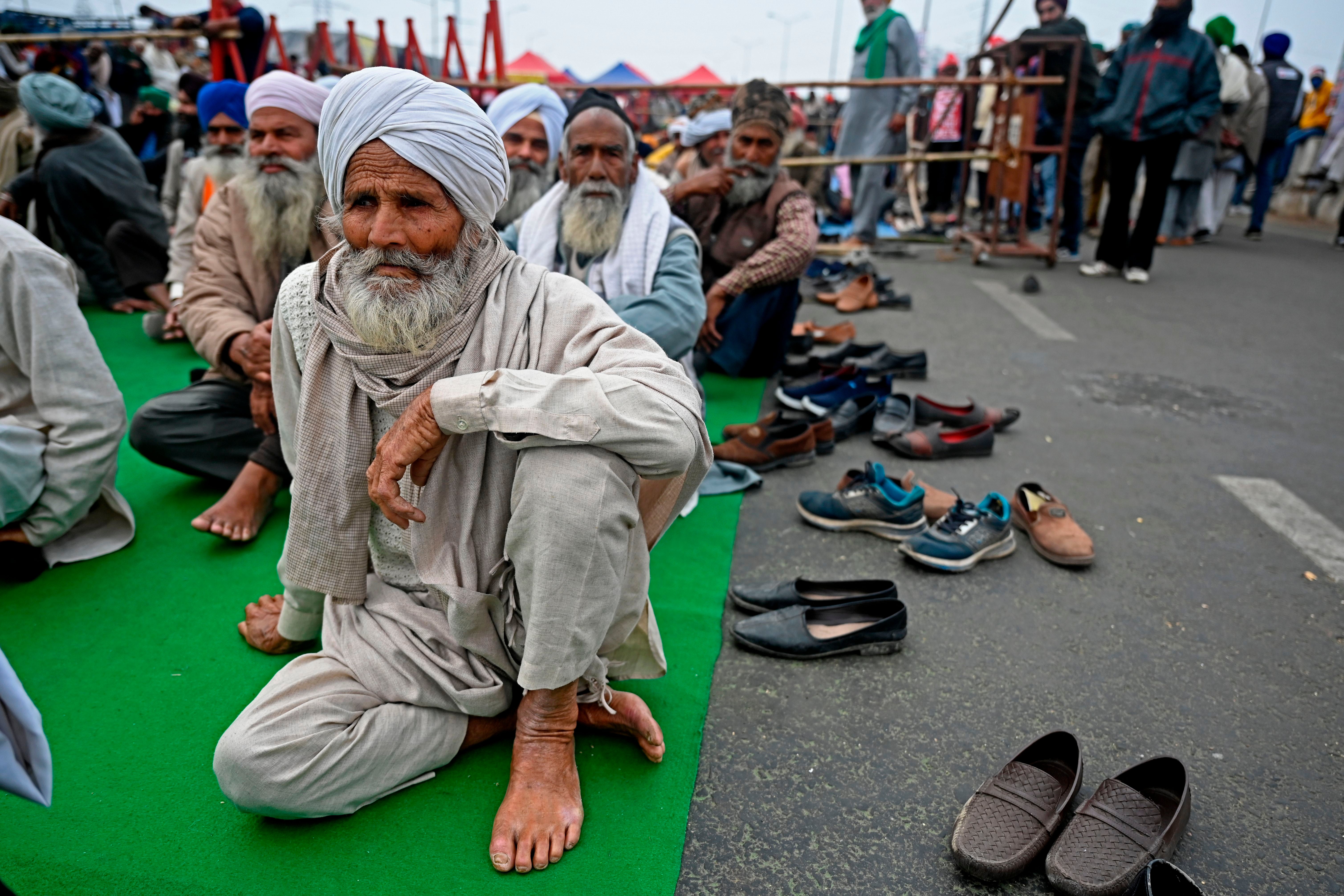 Farmers sit along a blocked highway as they continue to protest against the central government's recent agricultural reforms at the Delhi-Uttar Pradesh state border in Ghazipur on 18 January 2021