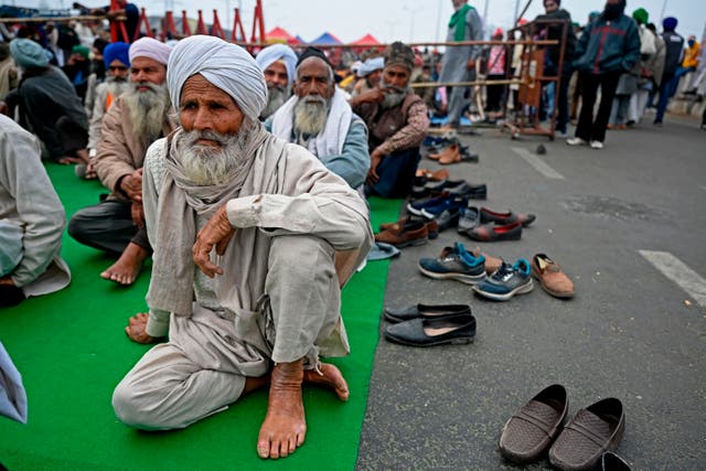 <p>Farmers sit along a blocked highway as they continue to protest against the central government's recent agricultural reforms at the Delhi-Uttar Pradesh state border in Ghazipur on 18 January 2021</p>