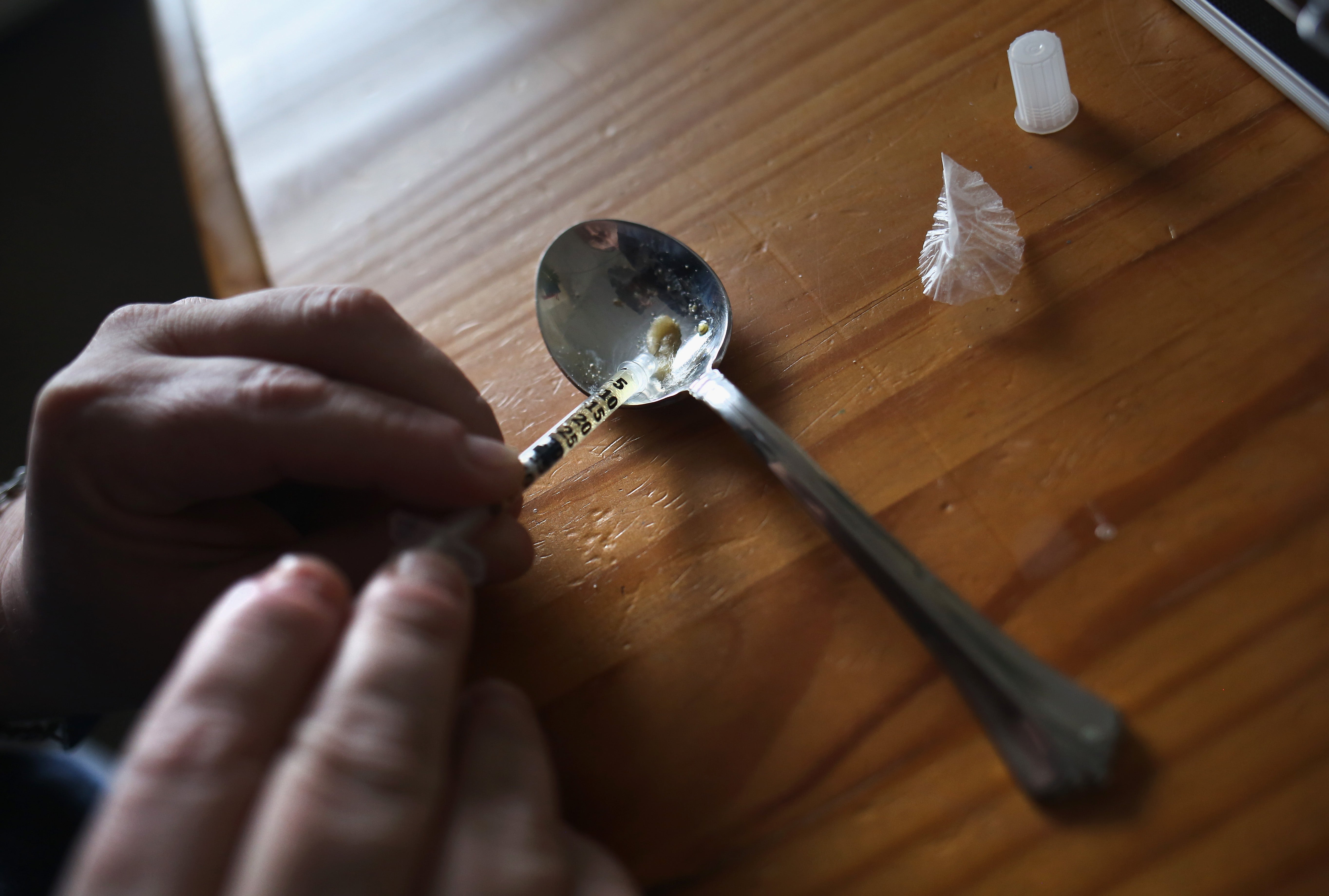 A heroin user prepares to inject himself